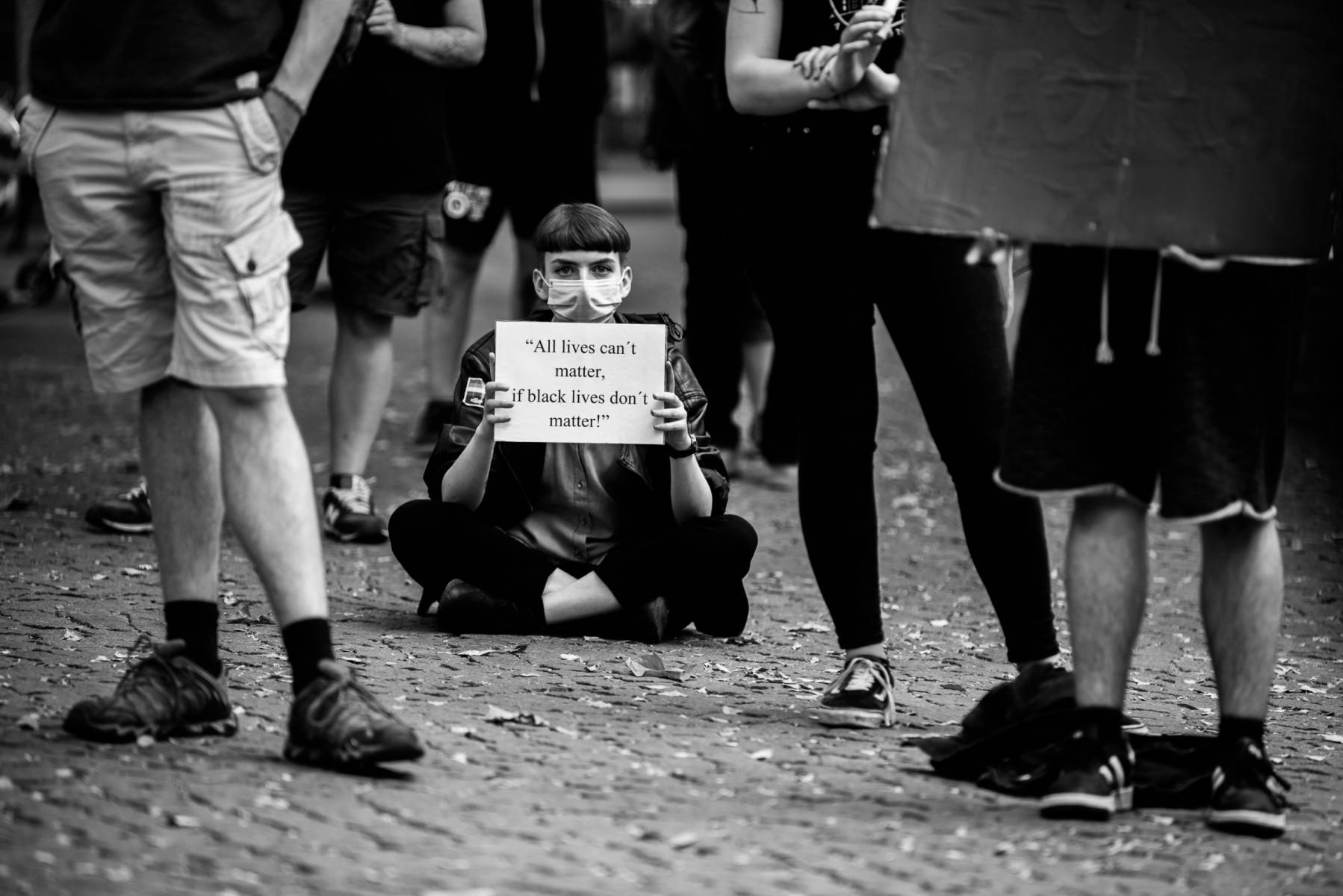 München, 03.06.2020 | Mahnwache am Rotkruezplatz für die Opfer rassistischer Polizeigewalt. 
Eine Demonstrantin hält ein Schild mit der Aufschrift: "All lives can't matter, if black lives don't matter!"