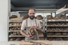 München, Maxvorstadt 2019 | Bäcker hält Brot.
Julius Brantner betreibt seit 2019 die gläsern Backstube "Brothandwerk". Der 27-jährige gibt seinen Kunden die Möglichkeit ihm bei der Arbeit und dem Brot bei der Entstehung zuzuschaun. Alle Arbeitsschritte sind einsehbar. Er sagt, ich habe nichts zu verbergen und möchte perfektes ehrliches Brot anbieten.